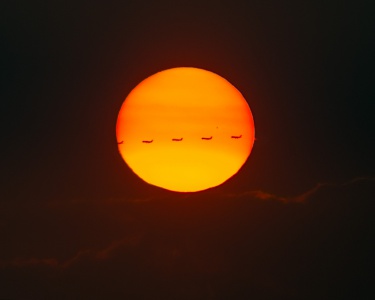 Airplane crossing sun